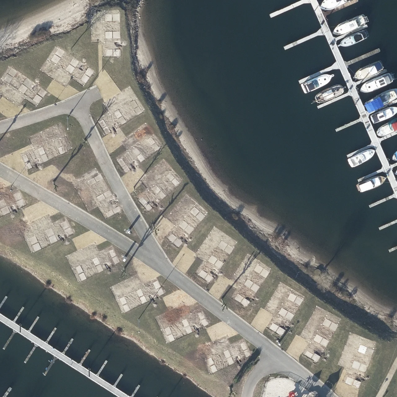 Original aerial image of a marina, boats and the curved shoreline.